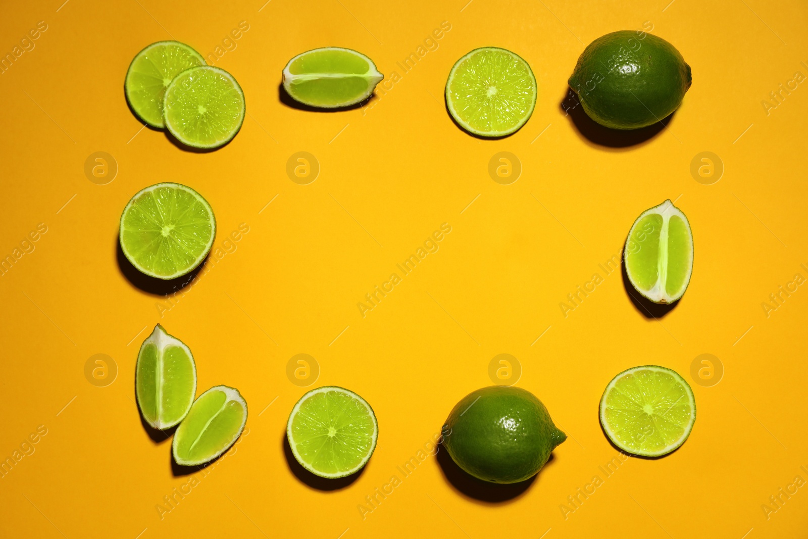 Photo of Flat lay composition with fresh juicy limes on yellow background. Space for text