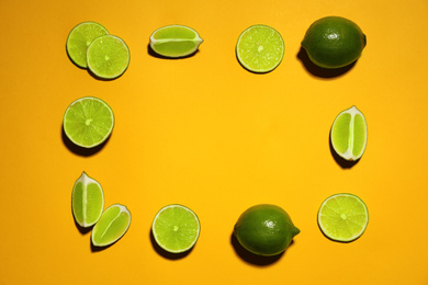 Photo of Flat lay composition with fresh juicy limes on yellow background. Space for text