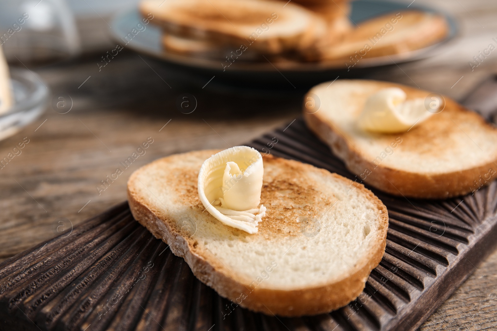 Photo of Toasted bread with butter on wooden board