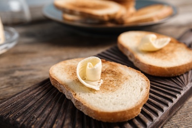 Toasted bread with butter on wooden board