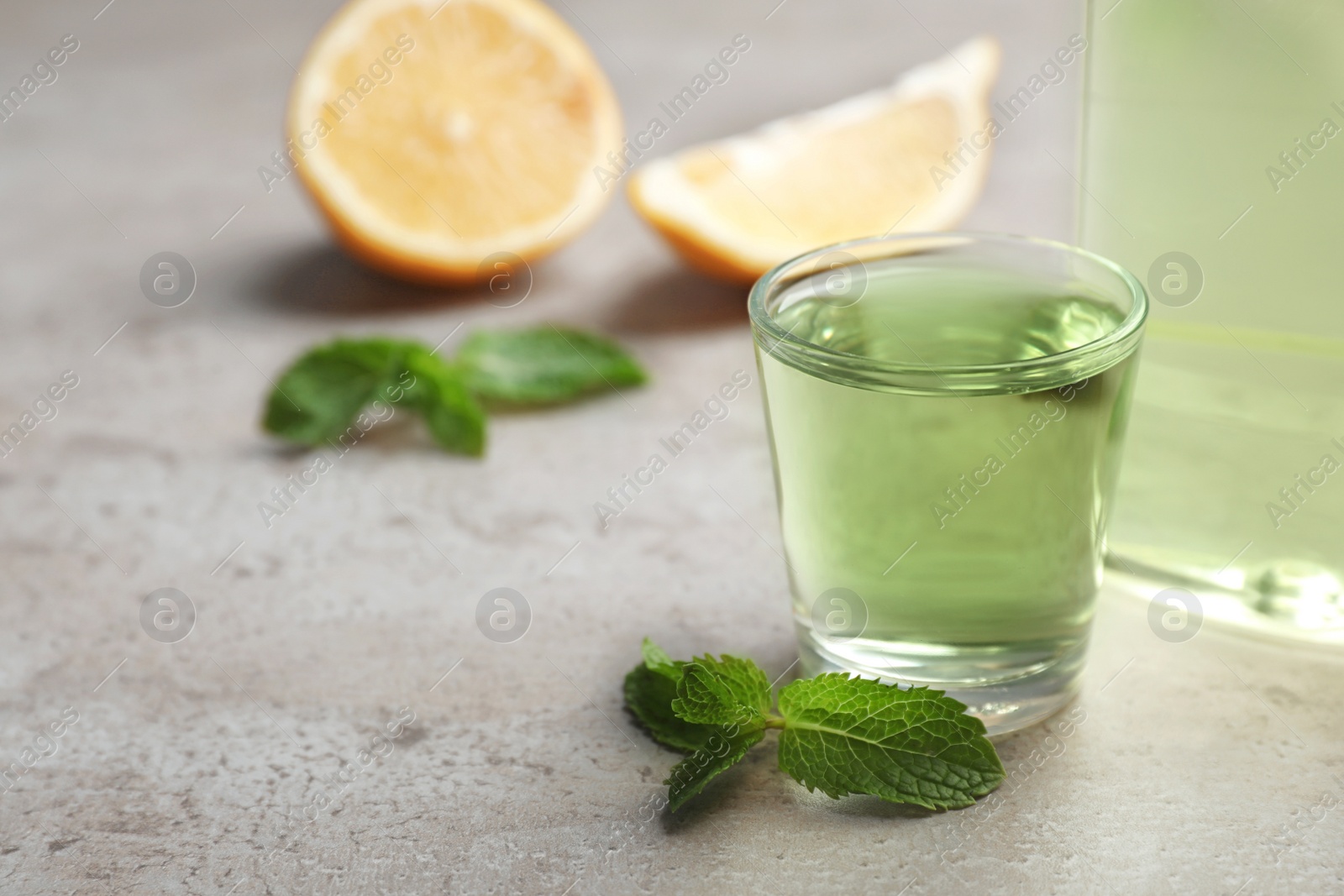 Photo of Glass with mouthwash, lemon and space for text on gray background. Teeth hygiene