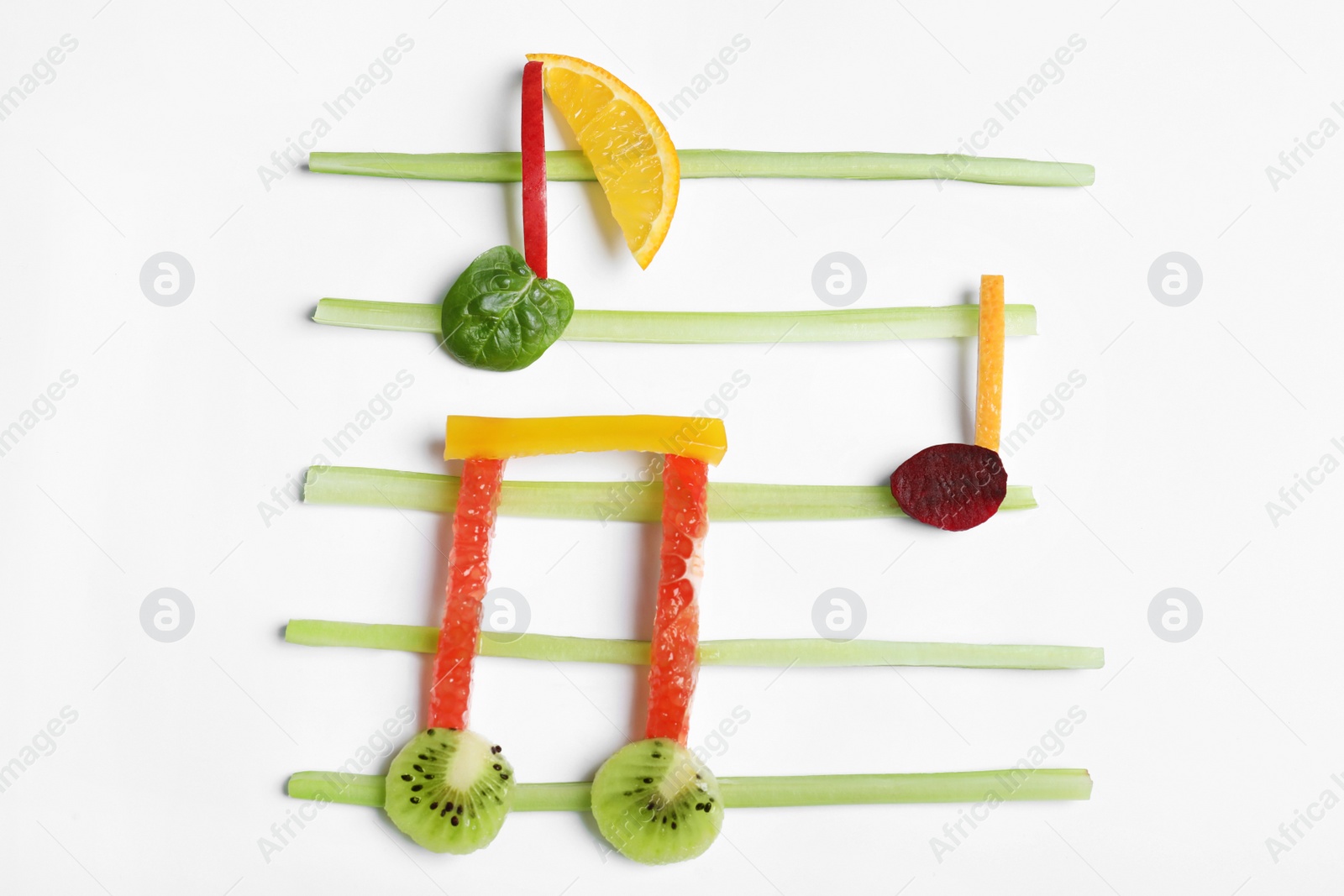 Photo of Musical notes made of fruits and vegetables on white background, top view
