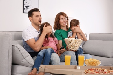 Photo of Family watching TV with popcorn in room