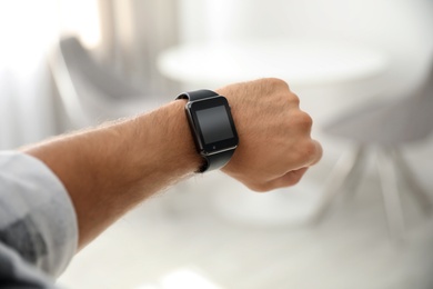 Photo of Man with smart watch on blurred background, closeup