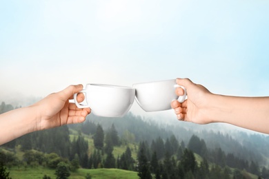 Closeness to nature. Couple with cups in mountains, closeup