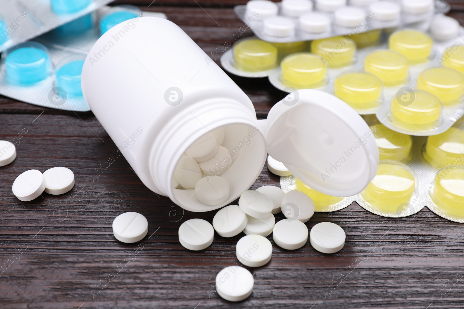 Photo of Many different pills on wooden table, closeup. Cough remedies