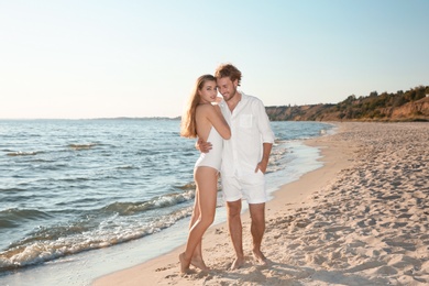 Photo of Romantic young couple spending time together on beach