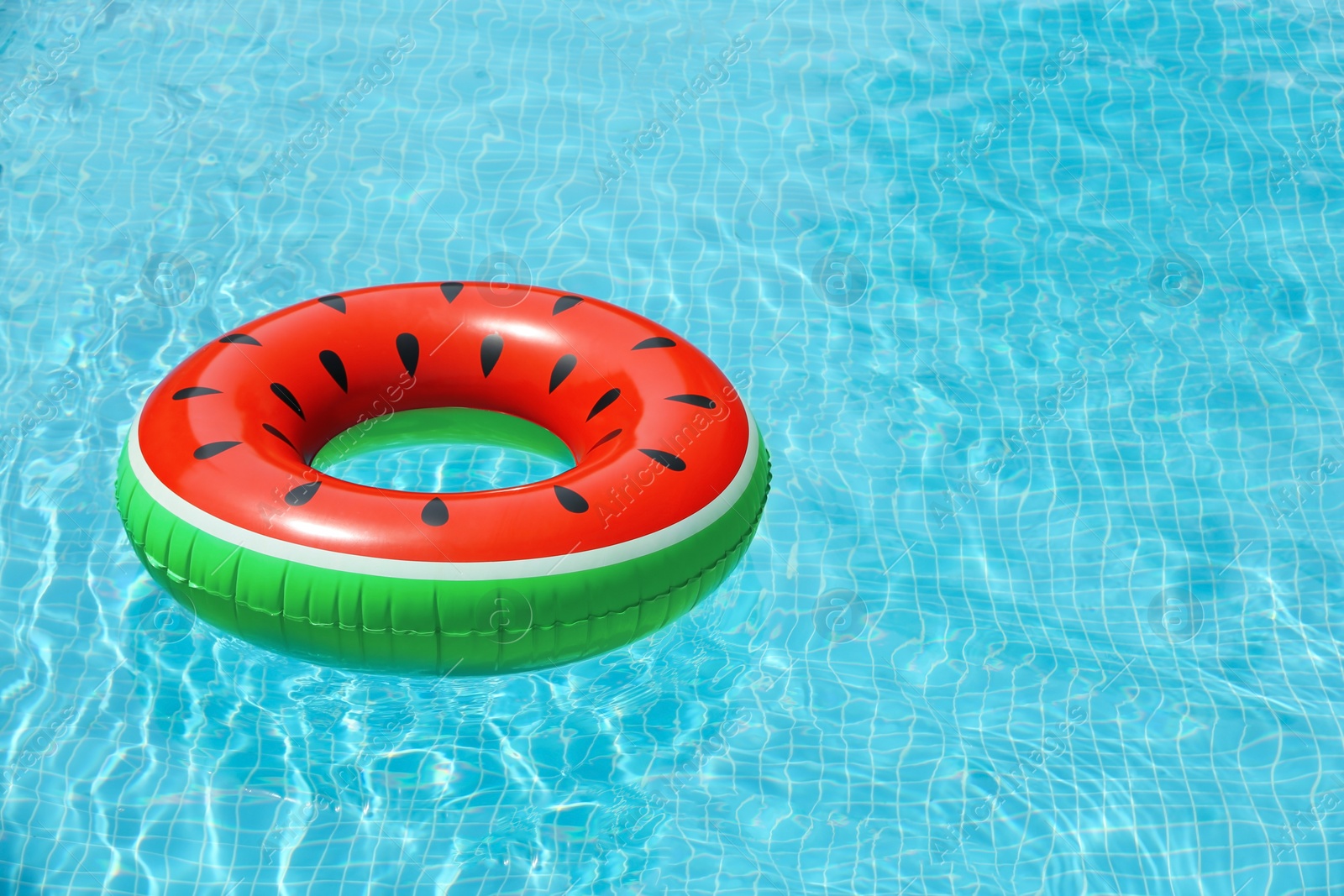 Photo of Inflatable ring floating in pool on sunny day