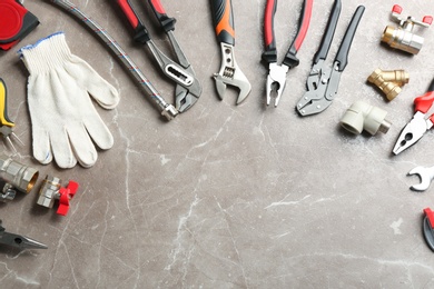 Photo of Flat lay composition with plumber's tools and space for text on grey background