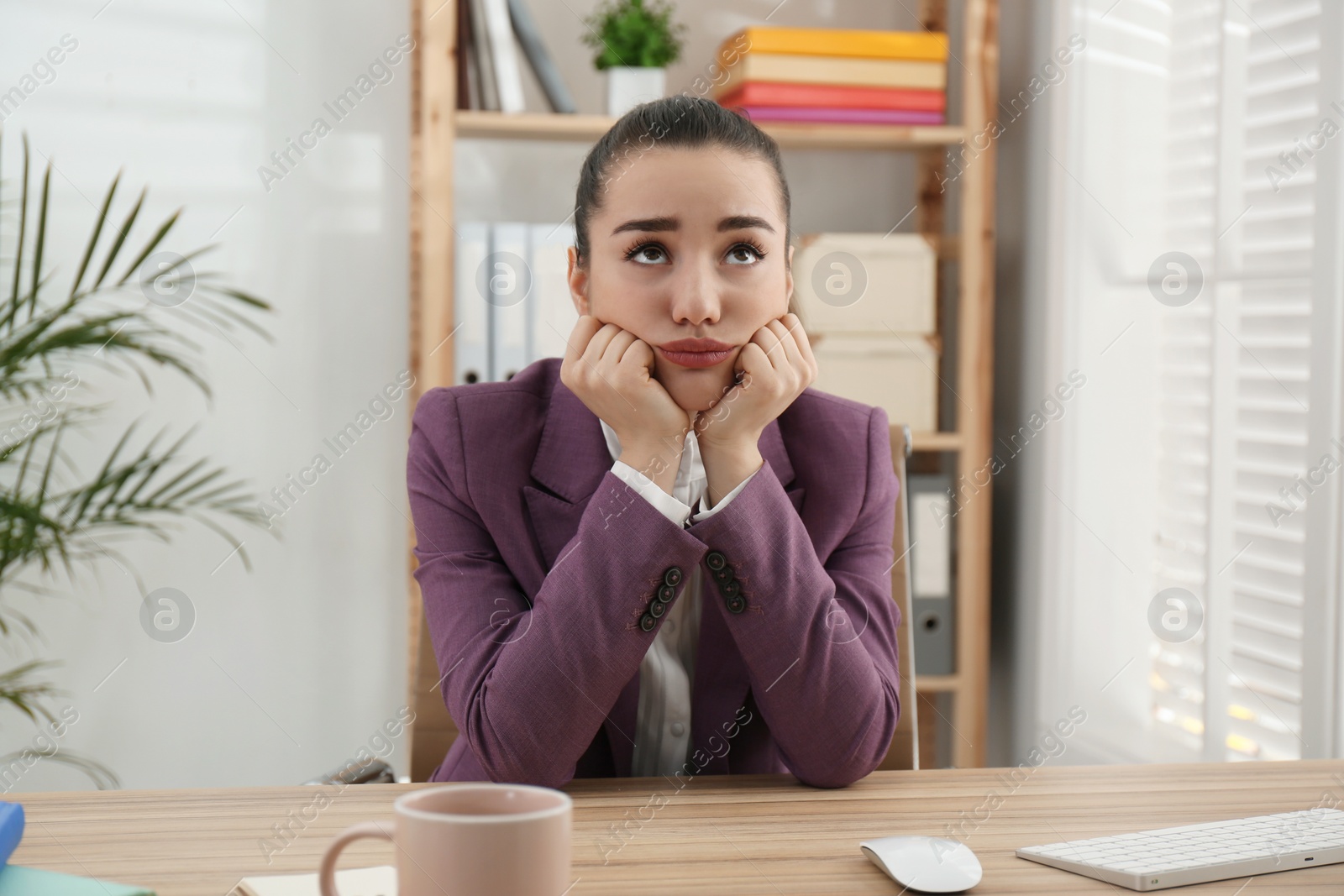 Photo of Lazy employee wasting time at table in office