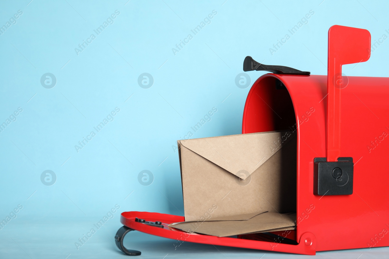 Photo of Open red letter box with envelopes on turquoise background, closeup. Space for text