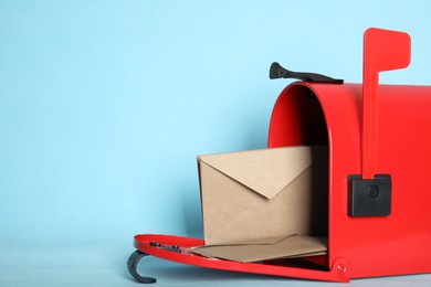 Open red letter box with envelopes on turquoise background, closeup. Space for text