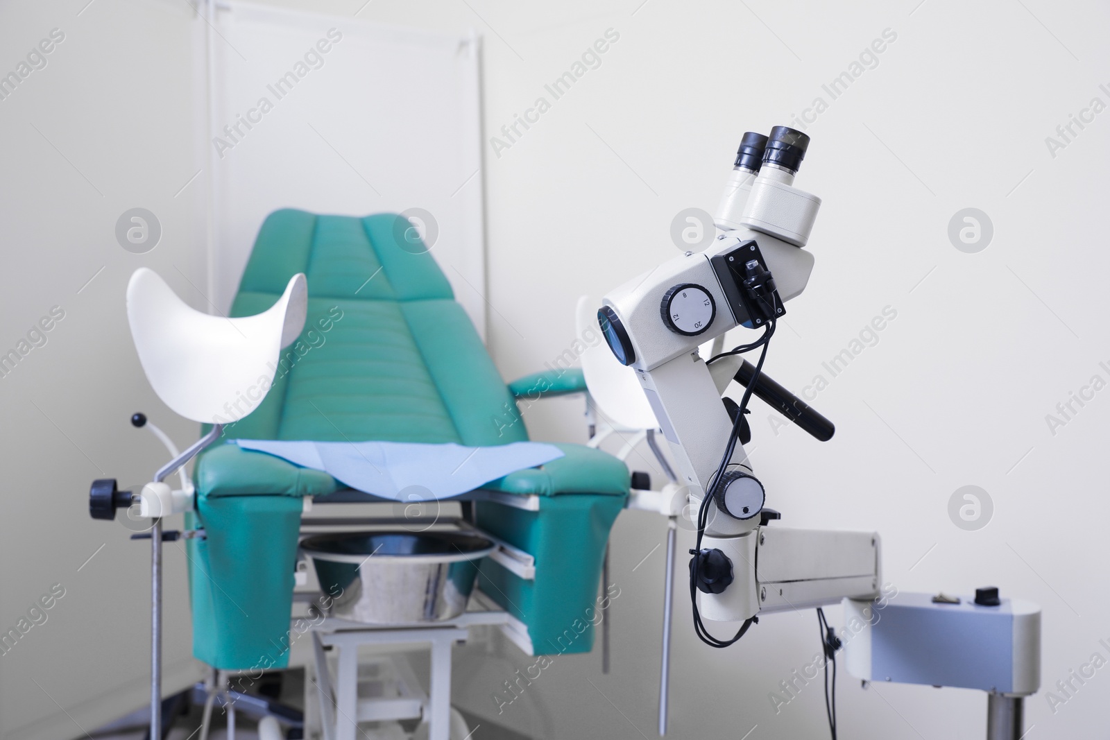 Photo of Modern binocular colposcope and gynecological chair in clinic