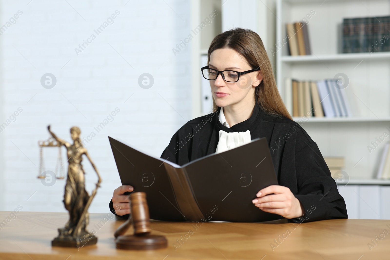 Photo of Judge with folder working indoors, selective focus