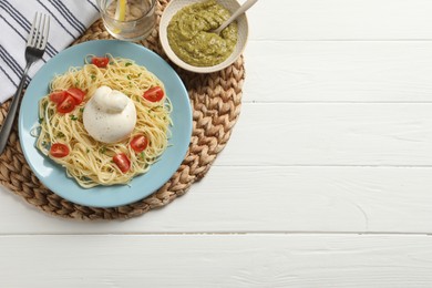 Photo of Plate of delicious pasta served with burrata, tomatoes and pesto sauce on white wooden table, top view. Space for text