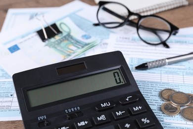 Photo of Tax accounting. Calculator, documents, money, glasses and pen on table, closeup