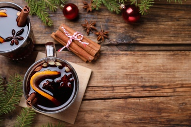 Flat lay composition with aromatic mulled wine on wooden table, space for text