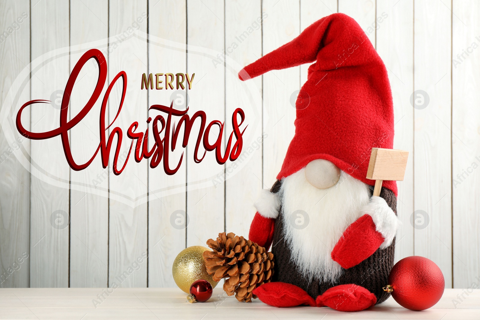 Image of Merry Christmas! Cute gnome and festive decor on table against white wooden background 