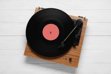 Photo of Turntable with vinyl record on white wooden background, top view