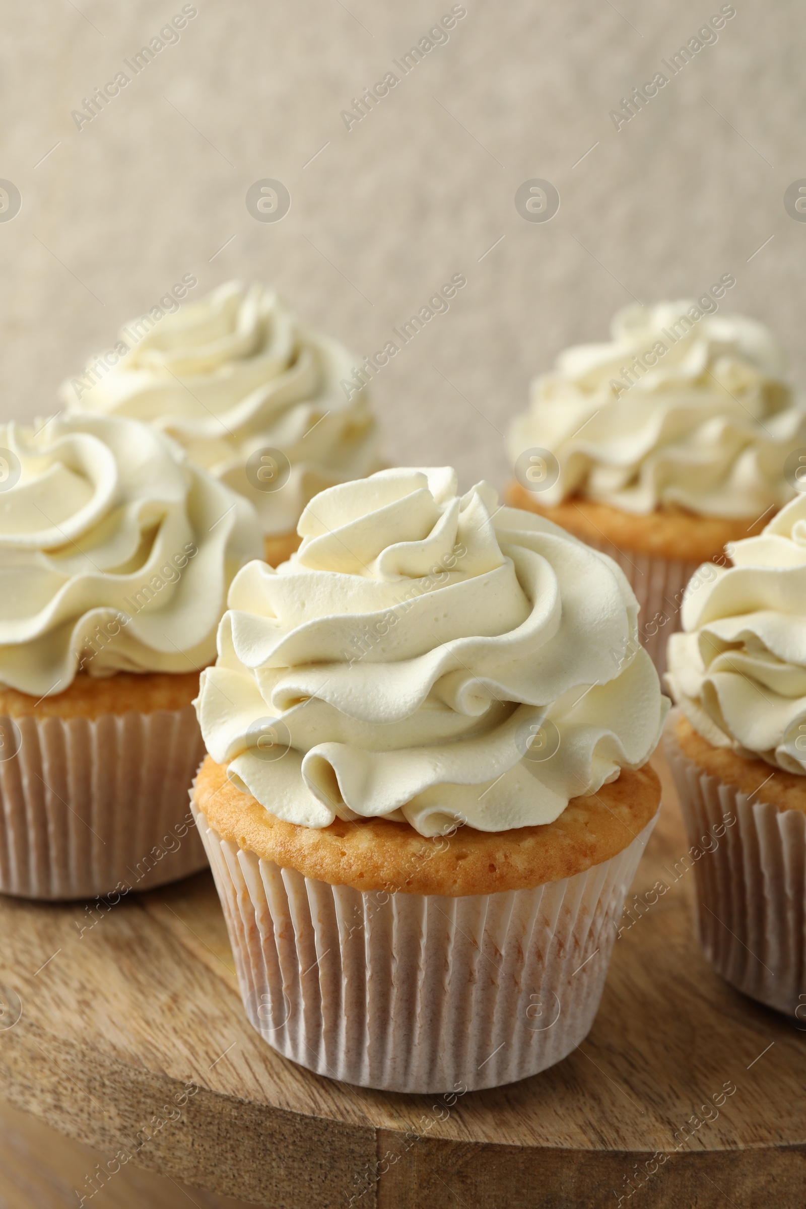 Photo of Tasty vanilla cupcakes with cream on table, closeup