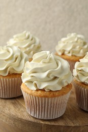 Photo of Tasty vanilla cupcakes with cream on table, closeup