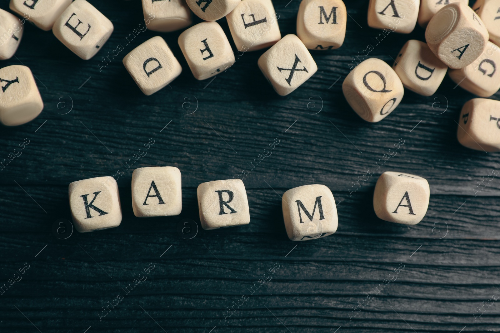 Photo of Cubes with word Karma on dark wooden background, flat lay