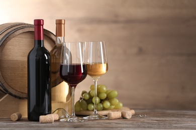 Photo of Composition with glasses and bottles of different wine on wooden table. Space for text