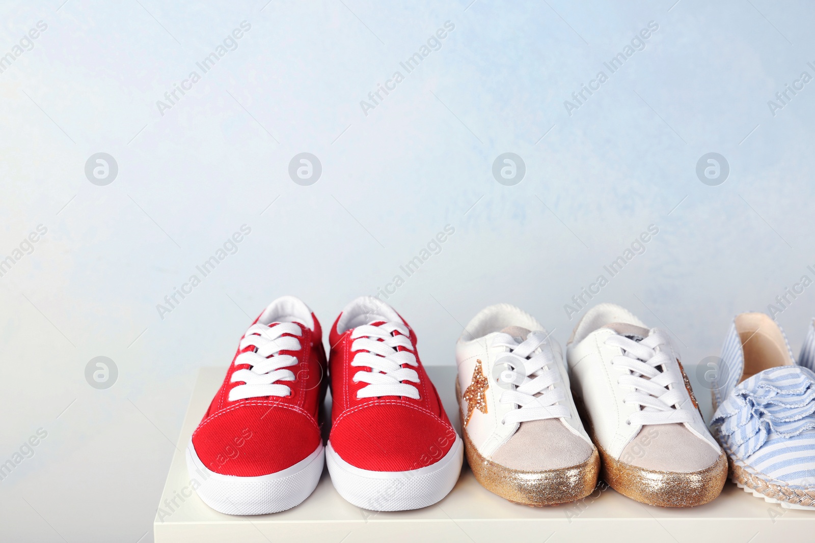 Photo of Stylish new shoes on table against light background