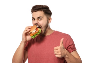 Photo of Handsome man eating tasty burger isolated on white