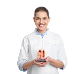 Photo of Female dentist holding teeth model on white background