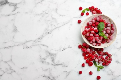 Tasty frozen red currants on white marble table, flat lay. Space for text