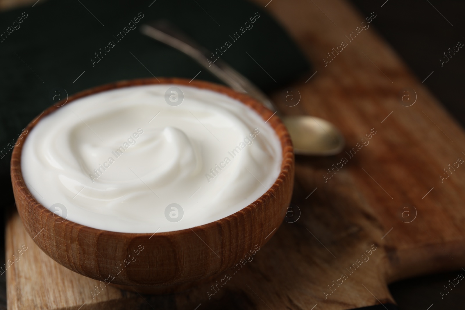 Photo of Delicious natural yogurt in bowl on table, closeup. Space for text