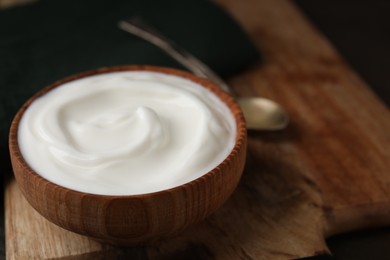 Photo of Delicious natural yogurt in bowl on table, closeup. Space for text