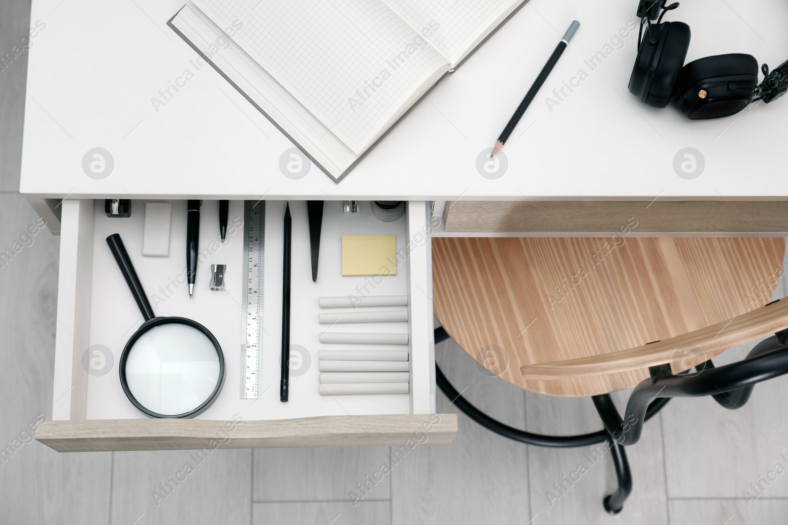 Photo of Office supplies in open desk drawer, top view