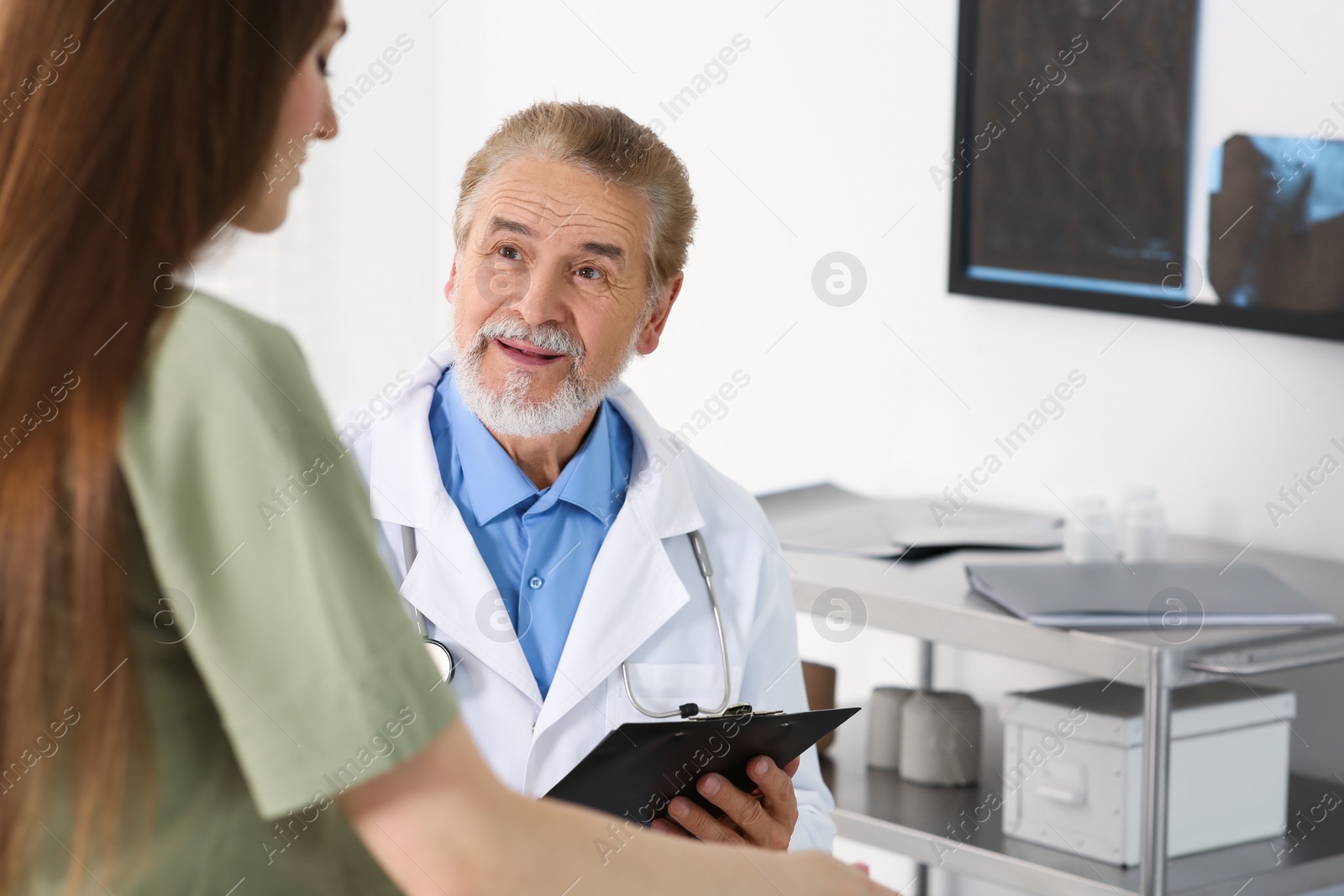 Photo of Professional orthopedist examining patient in clinic, space for text