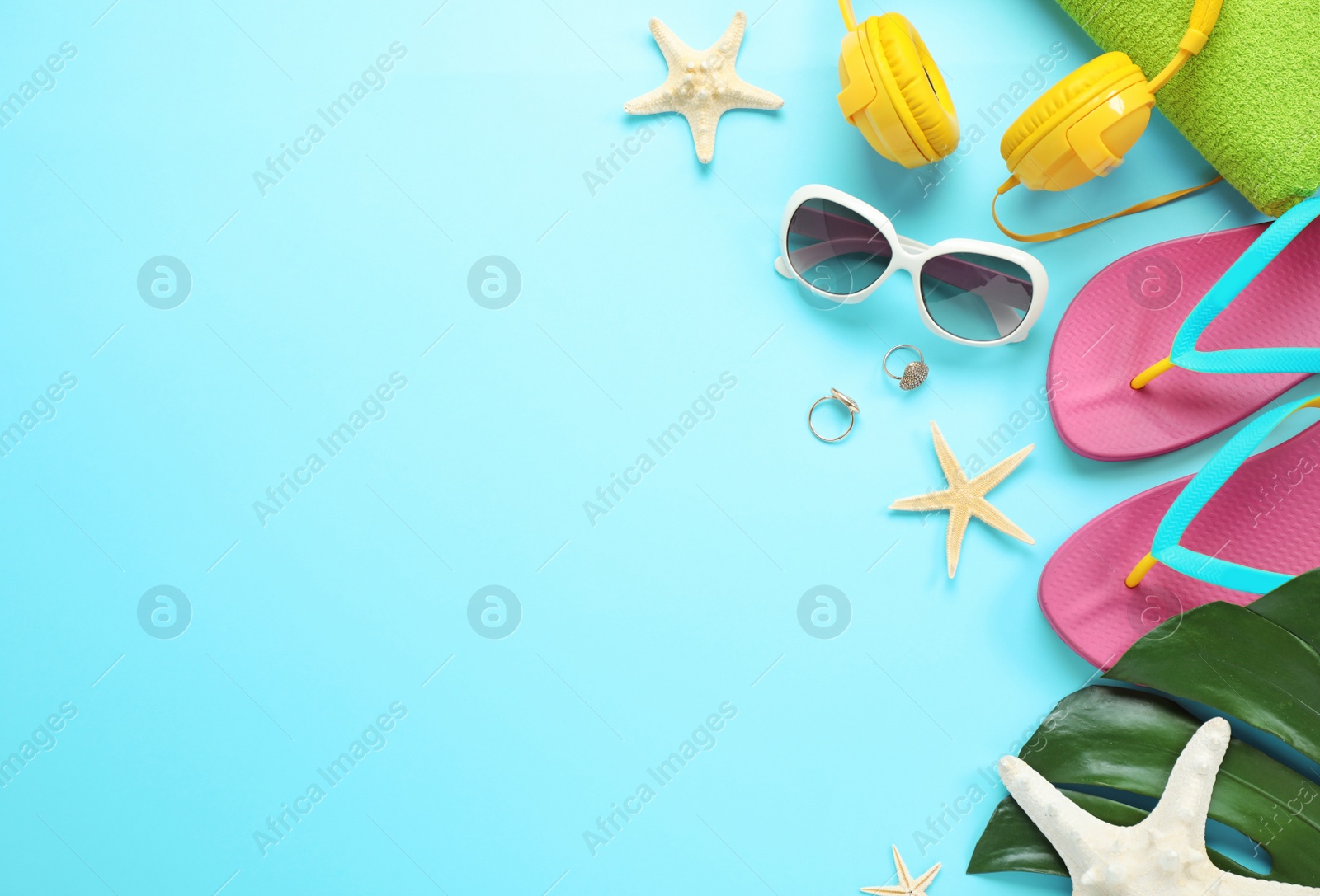 Photo of Flat lay composition with beach accessories on light blue background, space for text