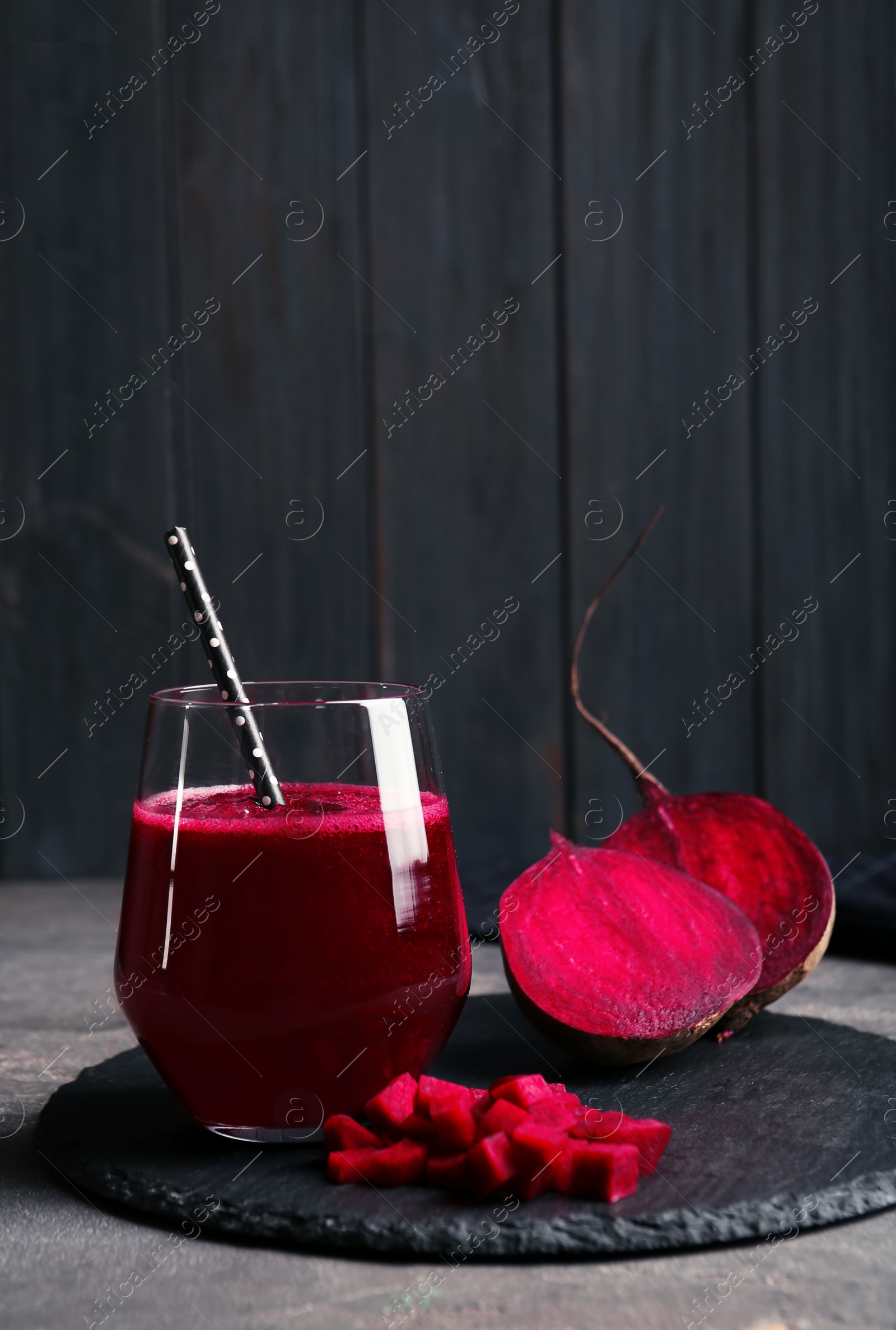 Photo of Slate plate with glass of beet smoothie on table, space for text