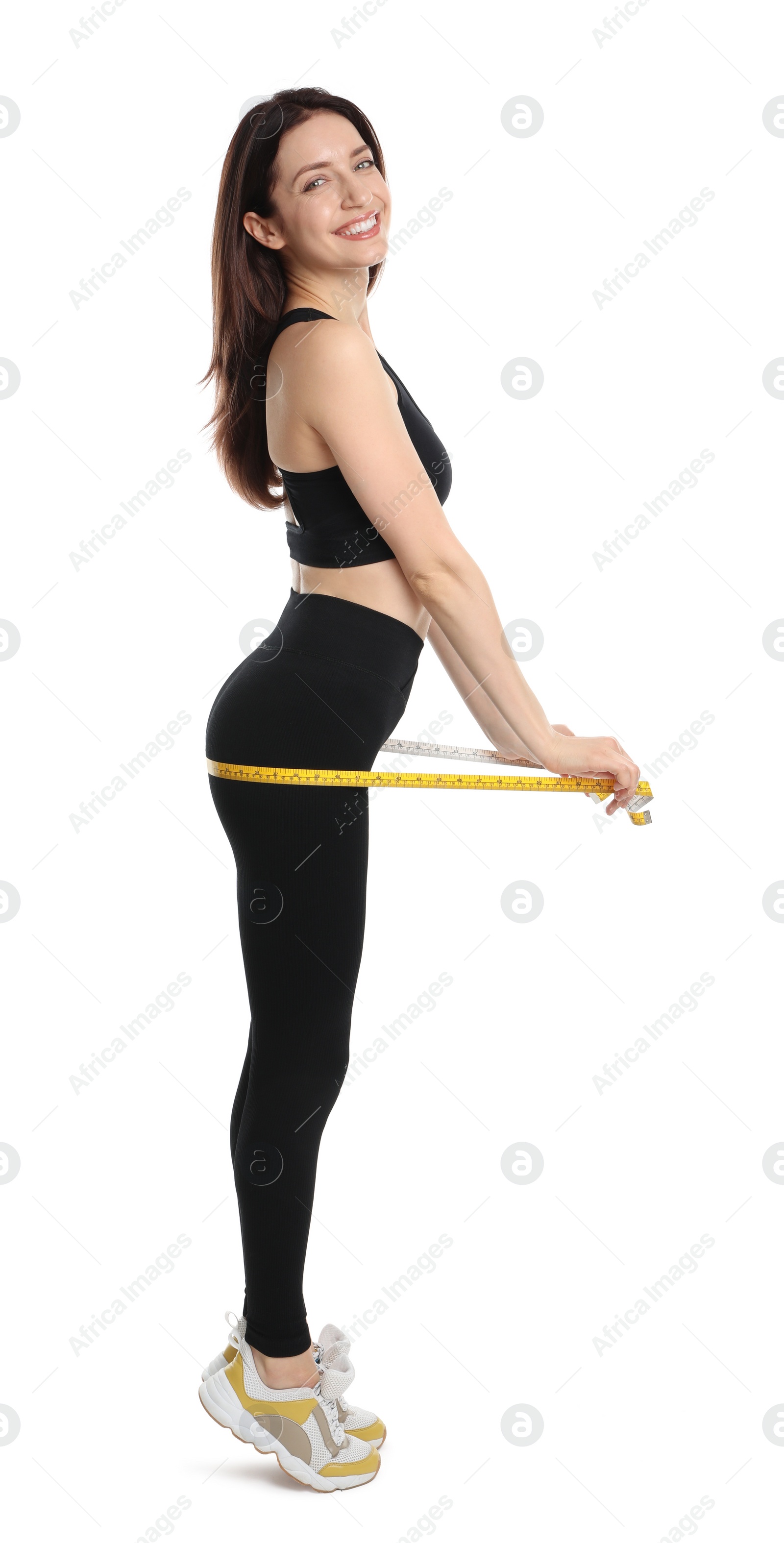 Photo of Happy young woman with measuring tape showing her slim body against white background