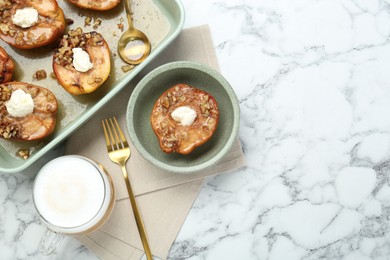 Tasty baked quinces with nuts and cream cheese served on white marble table, flat lay. Space for text