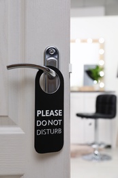Photo of Open door with sign PLEASE DO NOT DISTURB on handle at hotel