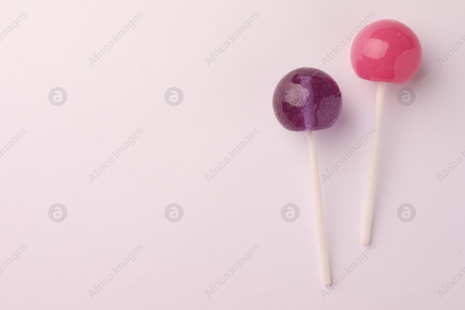 Photo of Tasty lollipops on white background, flat lay. Space for text