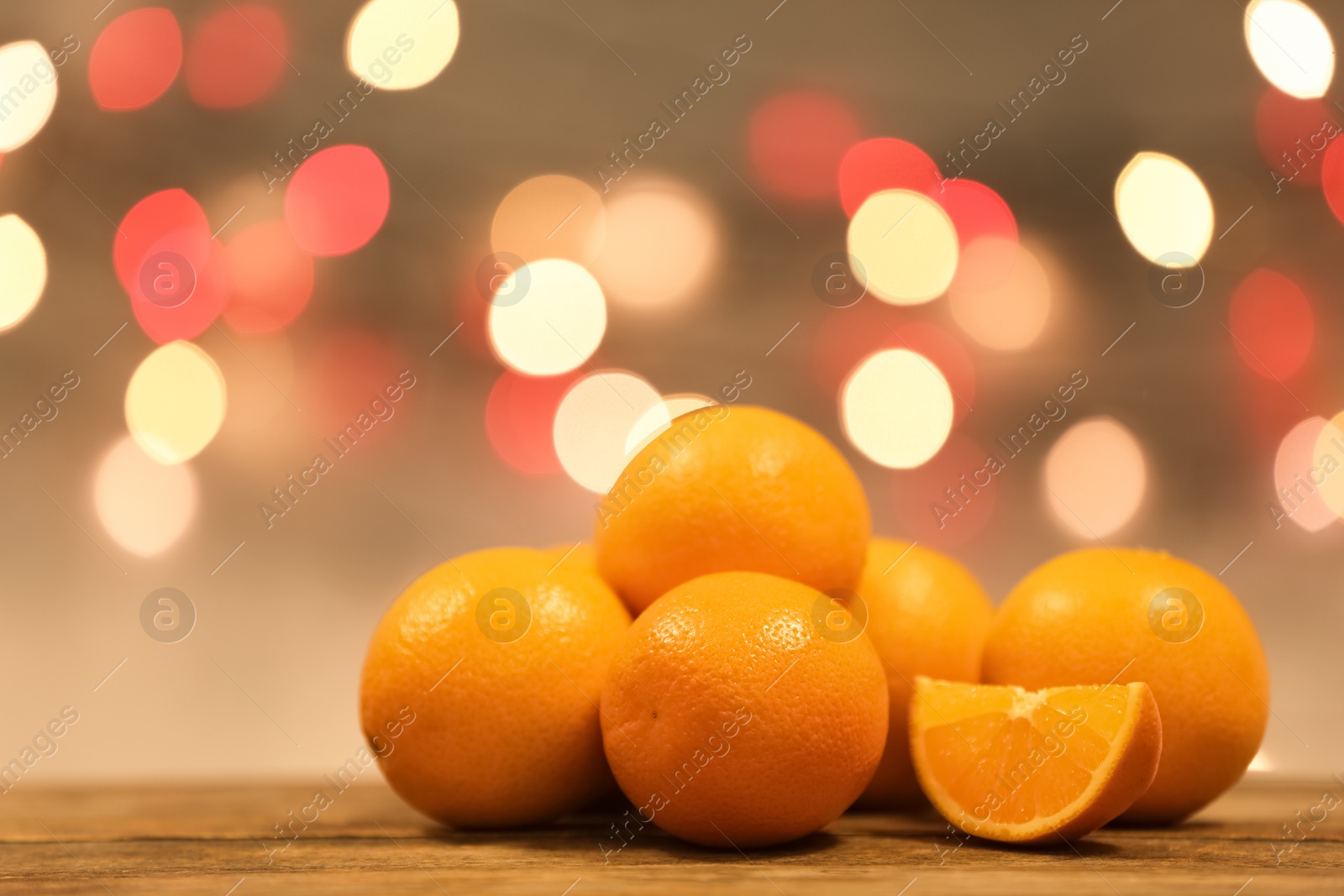 Photo of Fresh oranges on wooden table against blurred background. Space for text