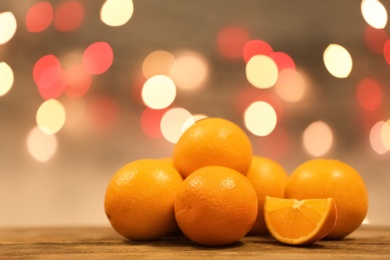 Fresh oranges on wooden table against blurred background. Space for text