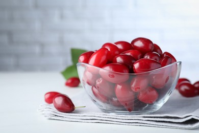 Photo of Fresh ripe dogwood berries on white table. Space for text