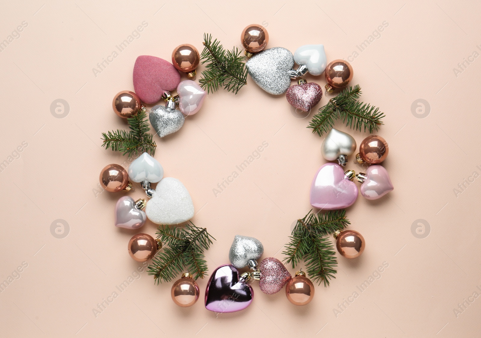 Photo of Beautiful festive wreath made of different Christmas balls and fir tree branches on beige background, top view