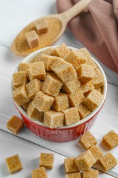 Photo of Bowl and spoon with brown sugar cubes, closeup