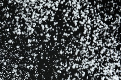 Photo of White snow falling down on black background