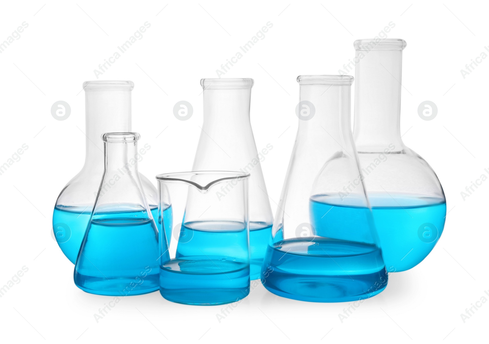 Photo of Different laboratory glassware with light blue liquid on white background