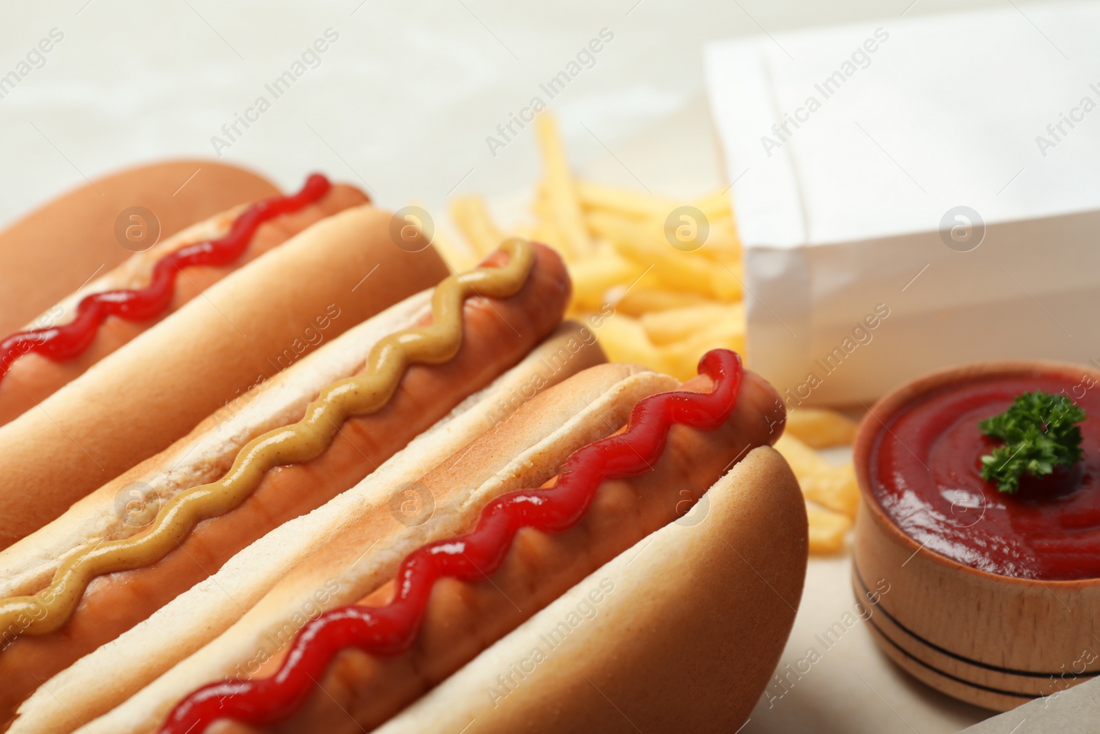 Photo of Tasty hot dogs with mustard and ketchup on table, closeup