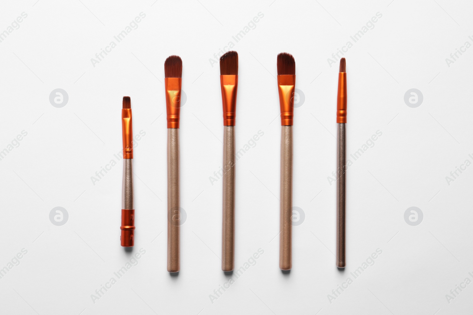 Photo of Different makeup brushes on white background, flat lay